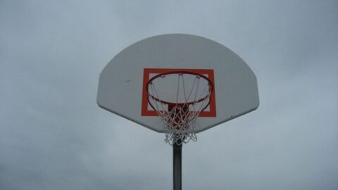 Basketball hoop and backboard against a cloudy sky