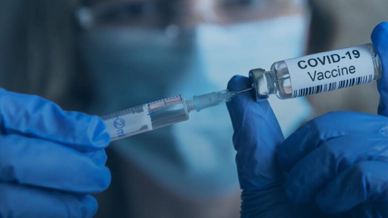 A vaccine vial and syringe in a clinic