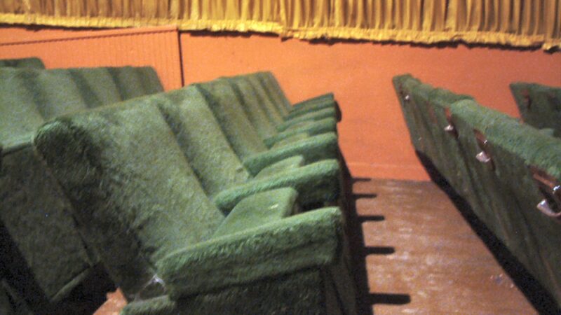 Empty green cinema seats in a classic theatre before the screening