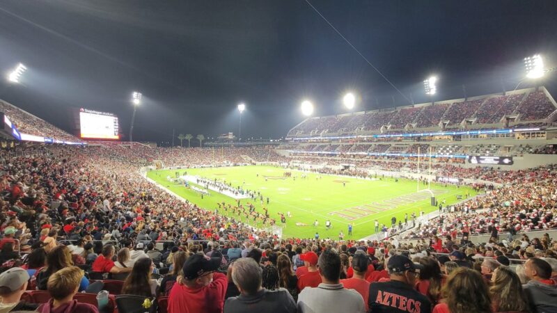 Football stadium at night under floodlights packed with fans