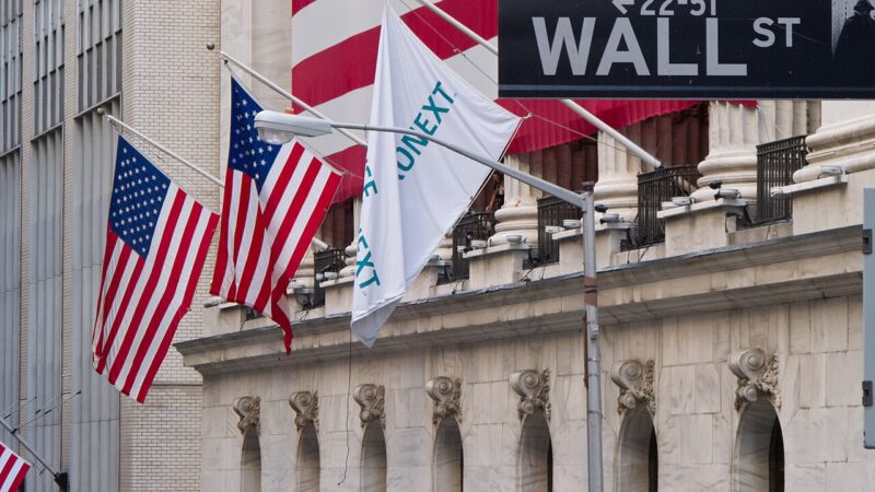 Wall Street sign in front of the New York Stock Exchange building